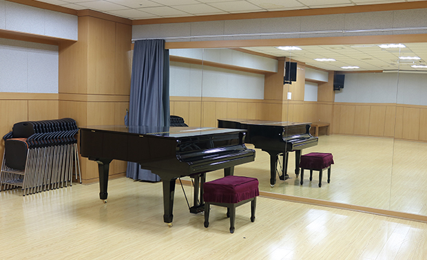 김포아트홀 연습실 내부 모습. 전면거울 앞에 그랜드피아노와 의자가 있음.